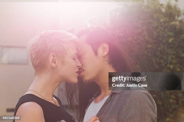 sweet couple kissing outside in the sun - beso en la boca fotografías e imágenes de stock