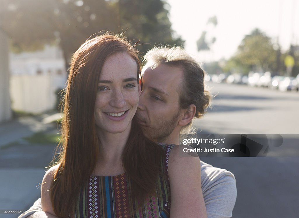 Man holding his girlfriend in the sunny street
