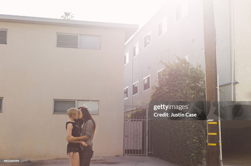 Lovers kissing in the sunny street