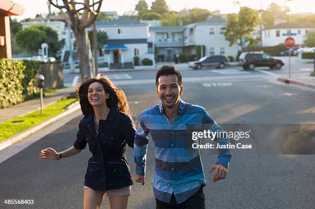 couple running joyfully in the street - running shorts foto e immagini stock
