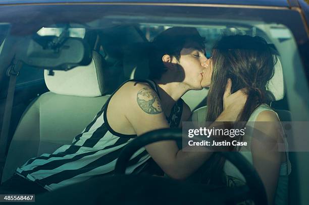 couple kissing inside a car - kussen stockfoto's en -beelden