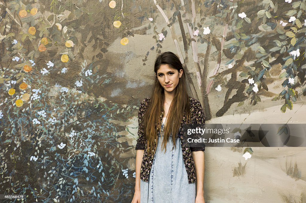 Portrait of young woman in front of a nature mural