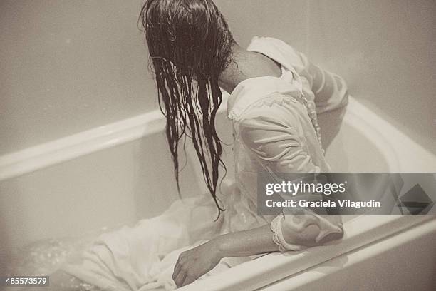 girl looking back in bath with white vintage dress - woman bath tub wet hair stock pictures, royalty-free photos & images