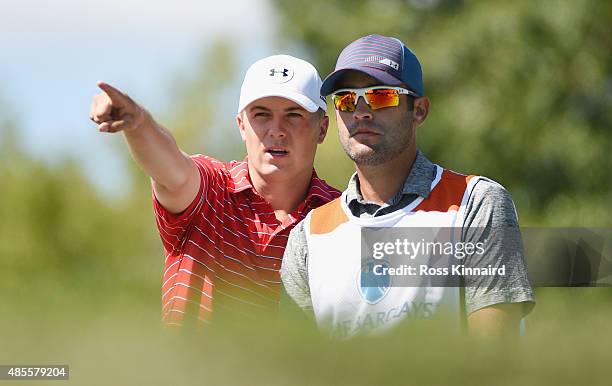 Jordan Spieth of the United States lines up his tee shot on the seventh hole with his caddie Michael Greller during the second round of The Barclays...