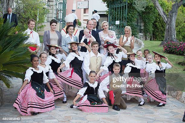 Prince Albert II of Monaco, Prince Jacques, Princess Charlene of Monaco and Princess Gabriella pose with dancers wearing traditional costumes during...