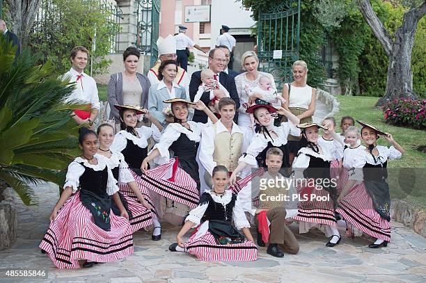 Prince Albert II of Monaco, Prince Jacques, Princess Charlene of Monaco and Princess Gabriella pose with dancers wearing traditional costumes during...