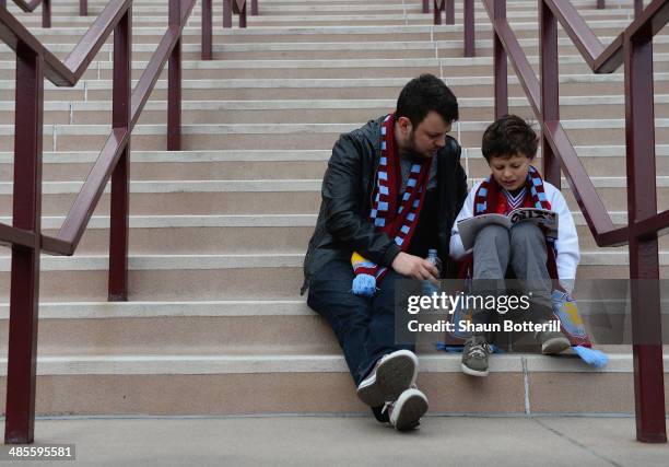 Young Villa fan and his dad read the match day programme before the Premier League match between Aston Villa and Southampton at Villa Park on April...