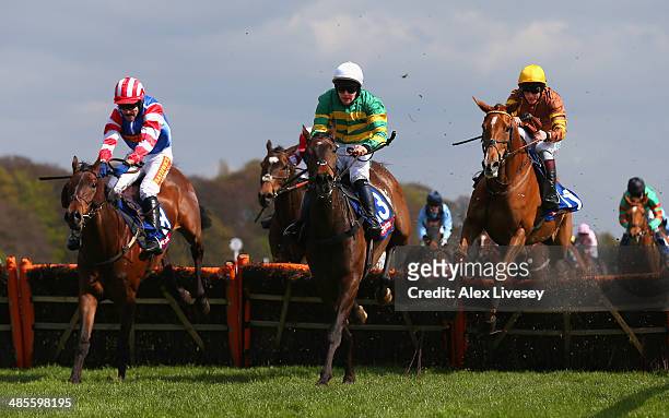 Carlton Jack ridden by Maurice Linehan jumps the last fence ahead of Heath Hunter ridden by Tom Scudamore and Generous Ransom ridden by Jamie Moore...