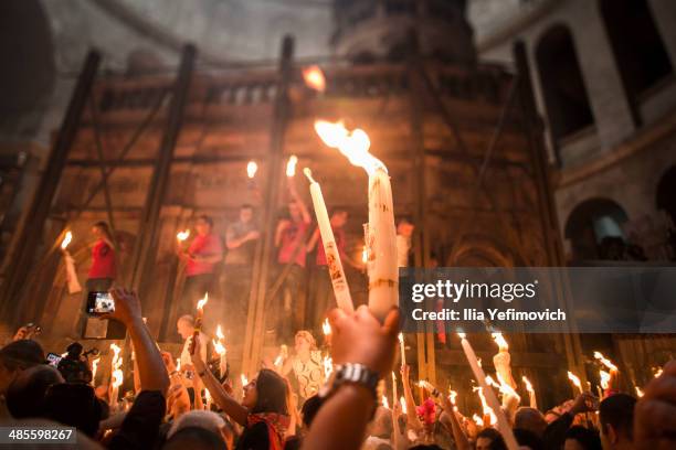 Christian Orthodox worshipers hold candles lit from a flame that emerged from the tomb believed to be of Jesus Christ as they take part in the...