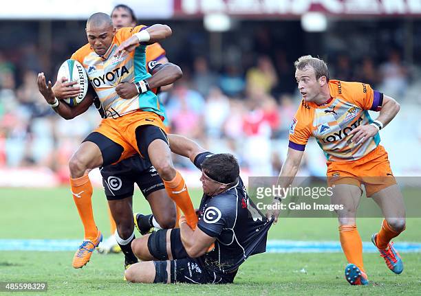 Cornal Hendricks of the Toyota Cheetahs tackled by Tonderai Chavhanga and Willem Alberts of the Cell C Sharks during the Super Rugby match between...