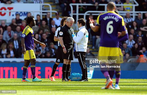 Referee Chris Foy recieves treatment after the official was hit in the face by the ball during the Barclays Premier League match between Newcastle...