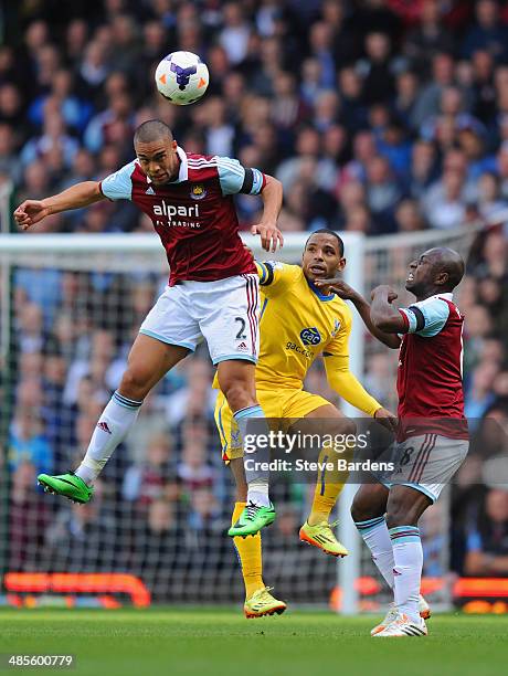 Winston Reid of West Ham heads the ball clear of Jason Puncheon of Crystal Palace during the Barclays Premier League match between West Ham United...