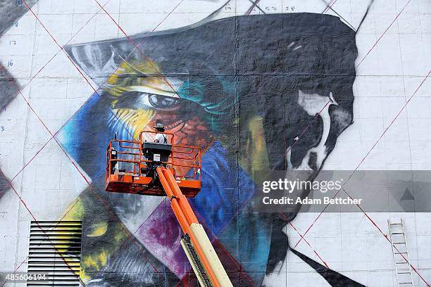 Brazilian artist Eduardo Kobra and his team paint a 60 foot by 150 foot mural of musician Bob Dylan on the side of a building on August 28, 2015 in...