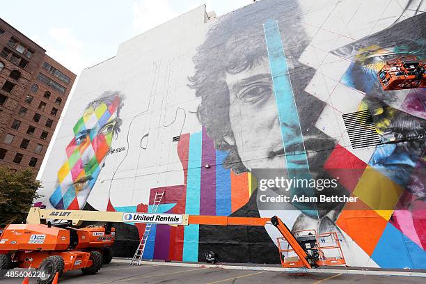 Brazilian artist Eduardo Kobra and his team paint a 60 foot by 150 foot mural of musician Bob Dylan on the side of a building on August 28, 2015 in...