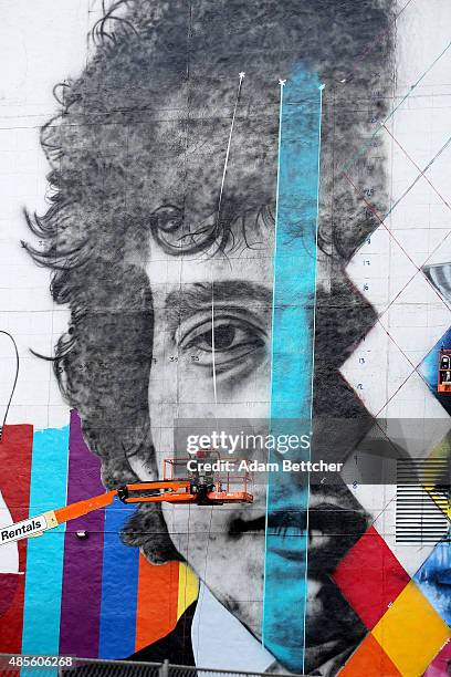 Brazilian artist Eduardo Kobra and his team paint a 60 foot by 150 foot mural of musician Bob Dylan on the side of a building on August 28, 2015 in...