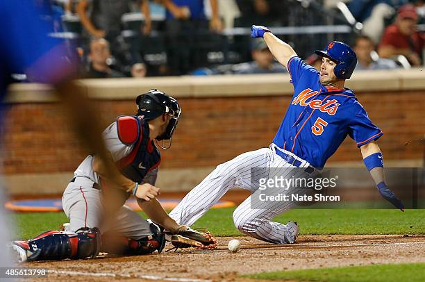 David Wright of the New York Mets scores as he slides in to home on an RBI triple by Michael Cuddyer in the fifth inning against catcher Blake...