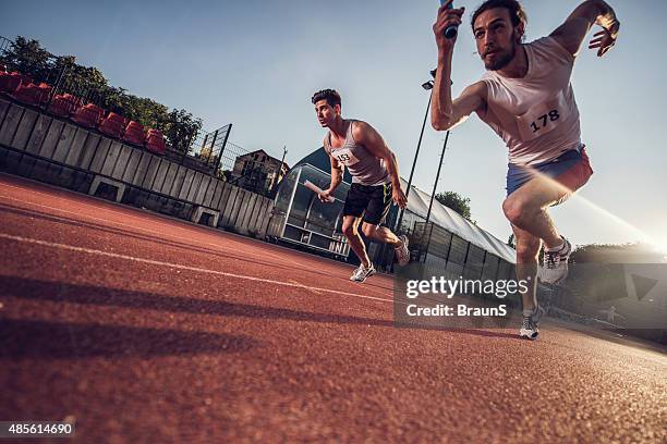 low angle view of athletes on a relay race. - stafett bildbanksfoton och bilder