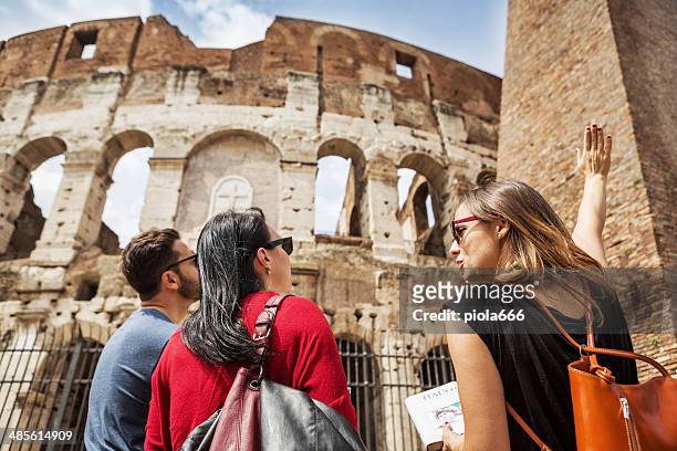 guida che spiega ai turisti il colosseo di roma - turista foto e immagini stock