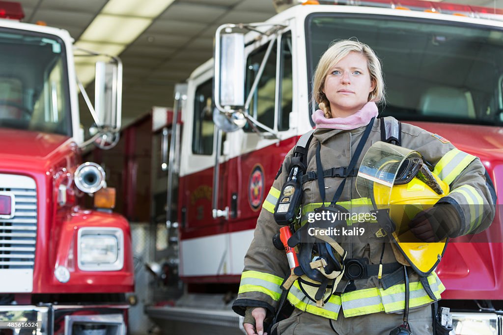 Female firefighter standing in front of fire truck