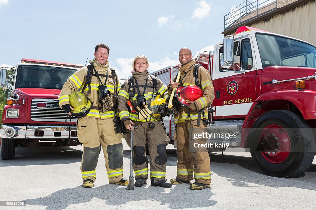 Firefighters em equipamento de protecção e de resgate Camiões