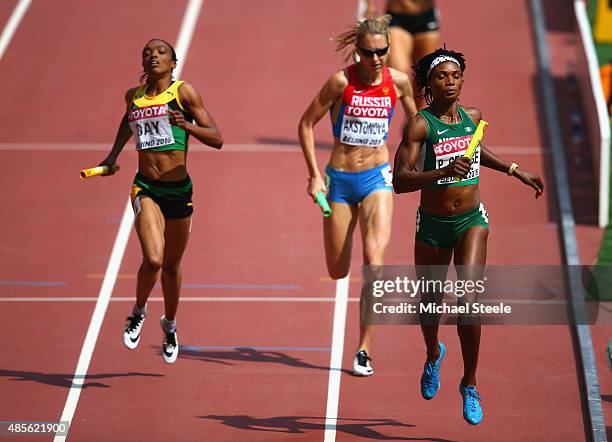 Christine Day of Jamaica, Kseniya Aksyonova of Russia and Patience Okon George of Nigeria compete in the Women's 4x400 Metres Relay heats during day...