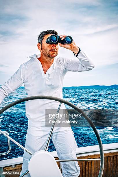 sailor with binoculars on sailboat - boat captain stockfoto's en -beelden