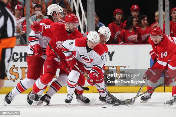 Andrei Loktionov and Manny Malhotra of the Carolina Hurricanes battles for the puck with Riley Sheahan and Gustav Nyquist of the Detroit Red Wings...