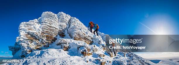 teenage mountaineer climbing snowy summit multiple exposure panorama winter sunburst - climbing snow mountain stock pictures, royalty-free photos & images