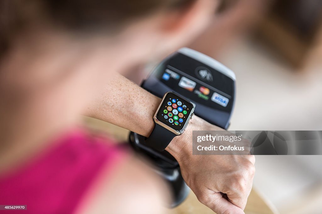 Woman Paying using Apple Watch and Electronic Reader