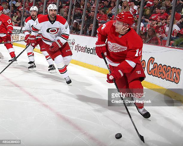 Gustav Nyquist of the Detroit Red Wings skates with the puck in front of Jay Harrison of the Carolina Hurricanes during an NHL game on April 11, 2014...