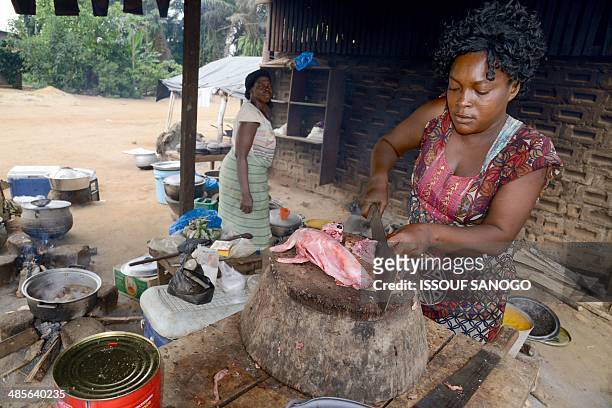 Woman cuts rabbit meat at a "maquis," a small African restaurant, in Kobakro, outside Abidjan, which used to serve bush meat, on April 8, 2014. The...