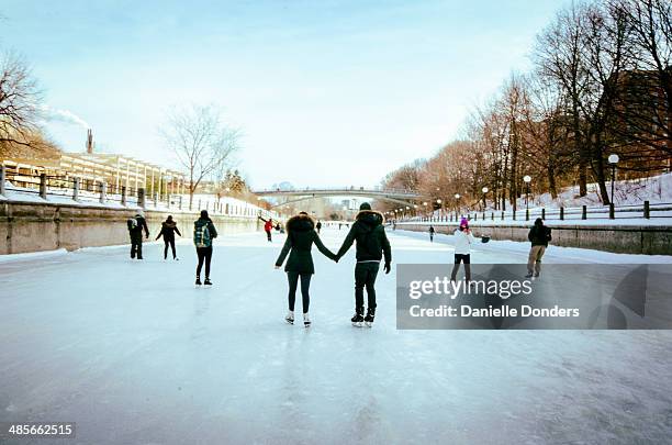 skaters holding hands on the rideau canal - ottawa stock pictures, royalty-free photos & images