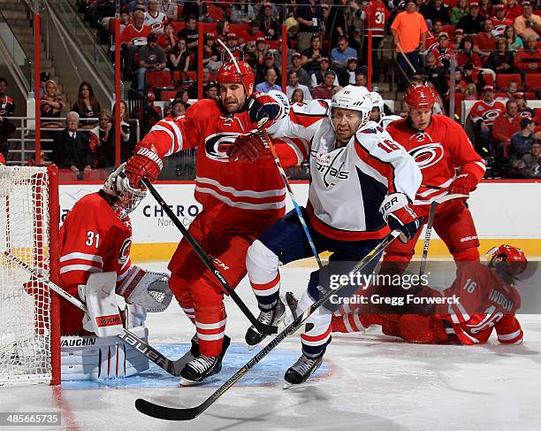 Jay Harrison of the Carolina Hurricanes battles near the crease with Eric Fehr of the Washington Capitals during their NHL game at PNC Arena on April...