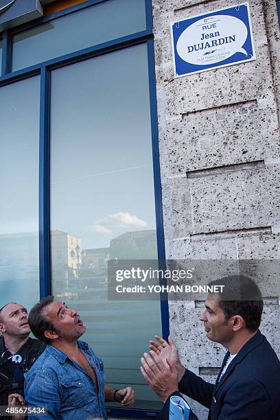 French actor Jean Dujardin reacts during the inauguration of a street to be temporarily named "Rue Jean Dujardin", flanked by Mayor of Angouleme...