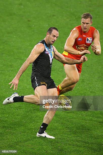 Matthew Broadbent of the Power kicks during the round 22 AFL match between the Gold Coast Suns and the Port Adelaide Power at Metricon Stadium on...