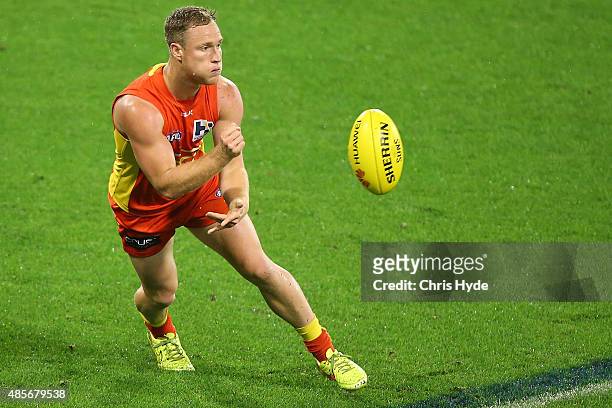 Brandon Matera of the Suns handballs during the round 22 AFL match between the Gold Coast Suns and the Port Adelaide Power at Metricon Stadium on...