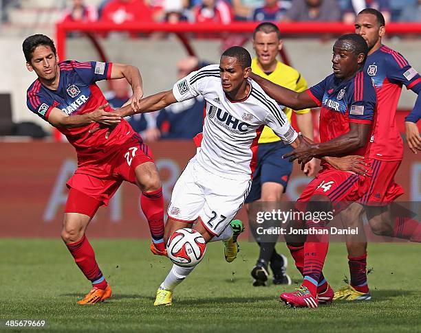 Victor Pineda and Jhon Kennedy Hurtado of the Chicago Fire try to hold back Jerry Bengtson of the New England Revolution during an MLS match at...