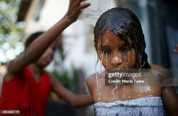 Girl is bathed with water collected from the one pipe with running water available to dozens of area residents in an impoverished section of the...