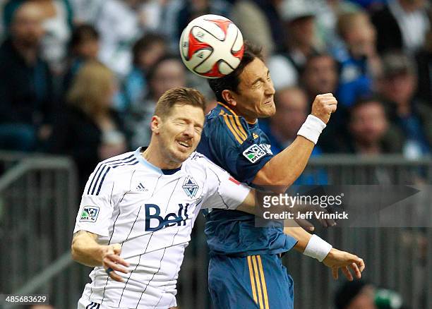 Jordan Harvey of the Vancouver Whitecaps FC and Stefan Ishizaki of the Los Angeles Galaxy head the ball during their MLS game April 19, 2014 in...