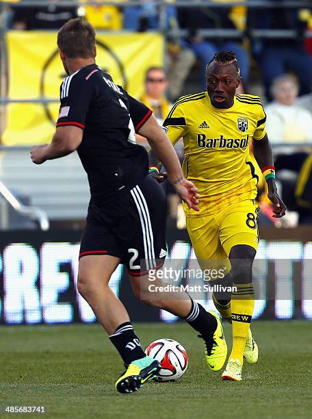 Columbus Crew forward Dominic Oduro dribbles the ball by D.C. United defender Jeff Parke during the first half at Columbus Crew Stadium on April 19,...