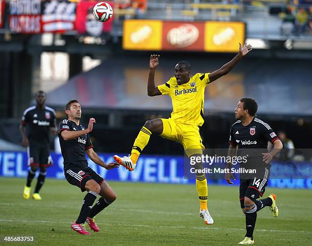 Columbus Crew midfielder Tony Tchani fights for the ball with D.C. United midfielder Perry Kitchen and Nick DeLeon during the first half of their...