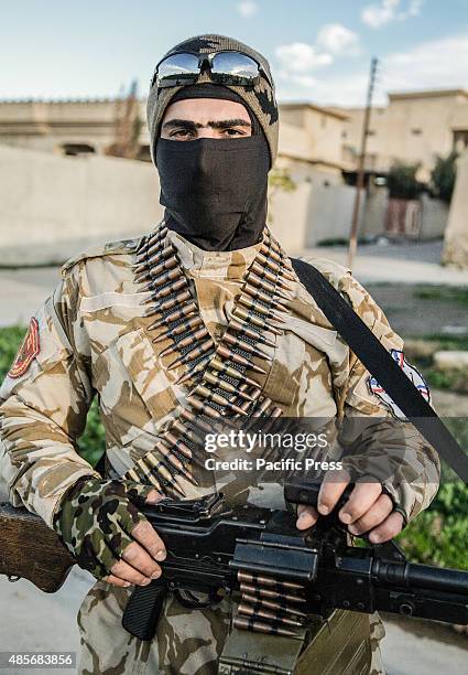 Soldier cover his face a mask and holding a heavy weapon.There are around 65 Christians pledged to fight alongside Peshmerga soldiers to protect the...