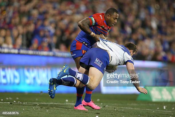 Akuila Uate of the Knights picks up Josh Morris of the Bulldogs during the round 25 NRL match between the Newcastle Knights and the Canterbury...