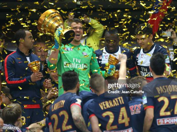 Goalkeeper Nicolas Douchez of PSG holds the trophy and celebrates with his teammates the victory at the end of the French League Cup Final between...