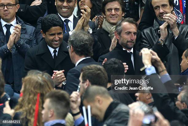 President of PSG Nasser Al-Khelaifi congratulates coach of PSG Laurent Blanc while director of PSG Jean-Claude Blanc looks on at the end of the...