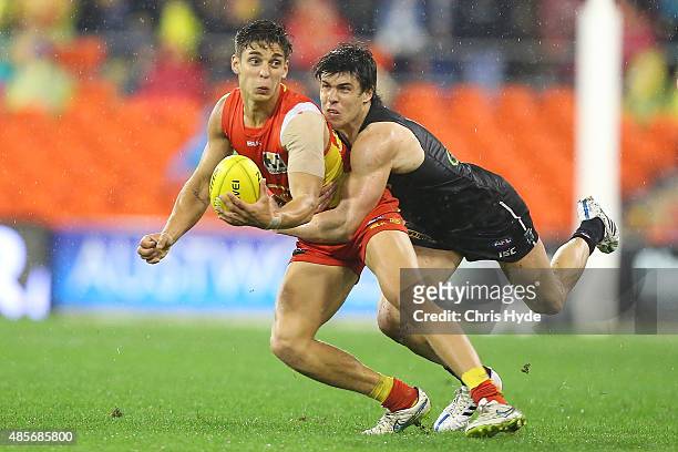 Sean Lemmens of the Suns is tackled by Angus Monfries of the Power during the round 22 AFL match between the Gold Coast Suns and the Port Adelaide...