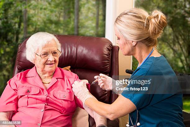 home healthcare nurse giving injection to elderly woman. - 2015 80-89 stock pictures, royalty-free photos & images