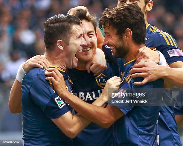 Stefan Ishizaki of the Los Angeles Galaxy is congratulated by teammates Robbie Keane and Landon Donovan as he celebrates his goal against the...