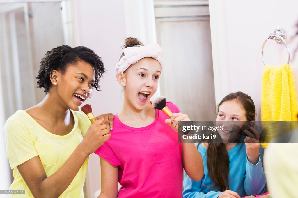 Girls at sleepover pretending to be singing stars