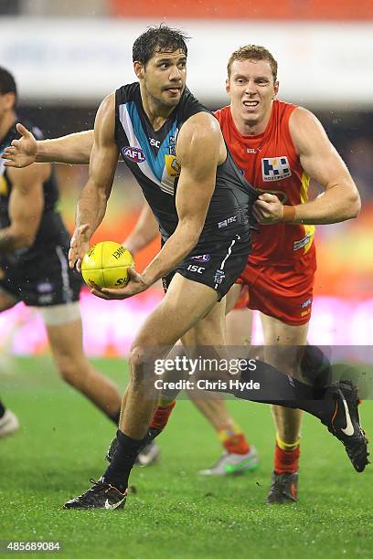 Patrick Ryder of the Power handballs during the round 22 AFL match between the Gold Coast Suns and the Port Adelaide Power at Metricon Stadium on...